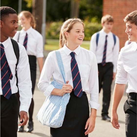Secondary school pupils chatting together as they walk outside school